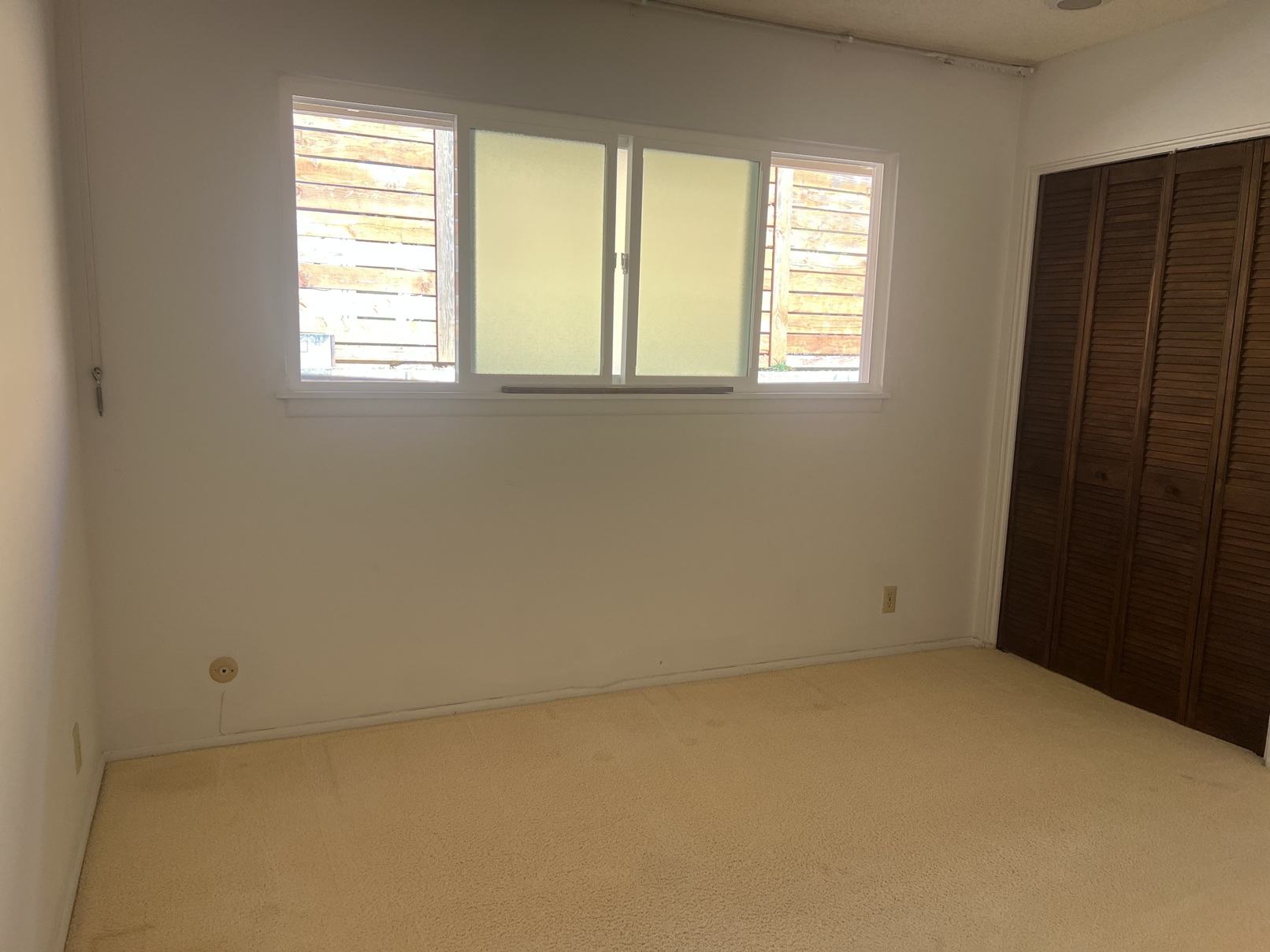 A room with a window and a door.